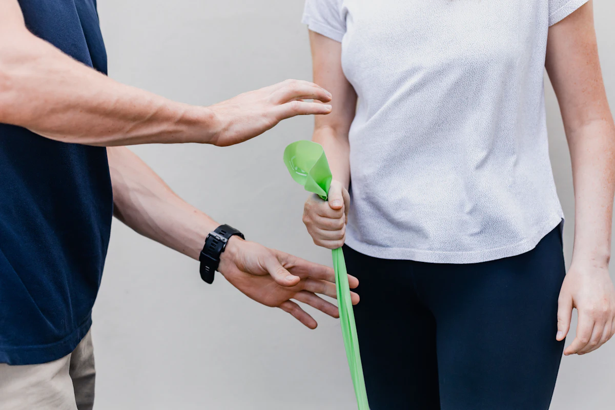 Übung mit einem grünen Therapieband unter Anleitung