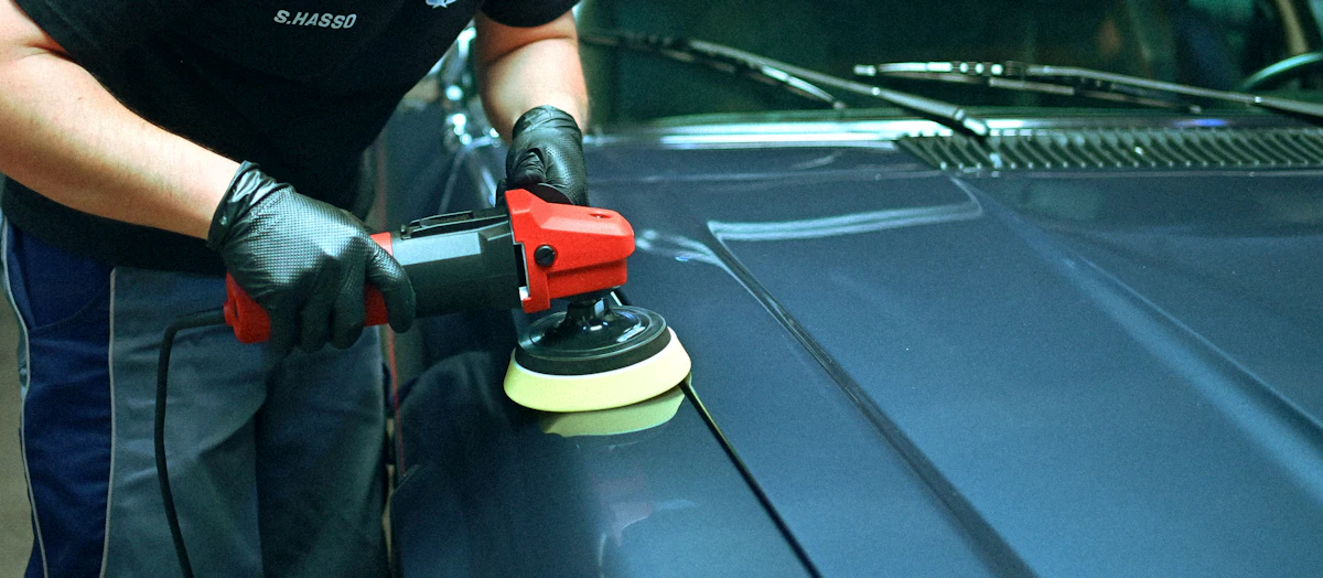 Poliermaschine auf einer blauen Motorhaube