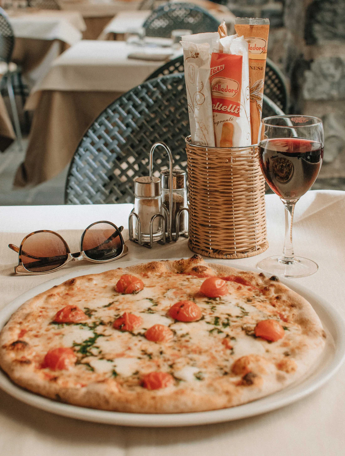 Pizza mit Tomaten auf einem Tisch im Freien